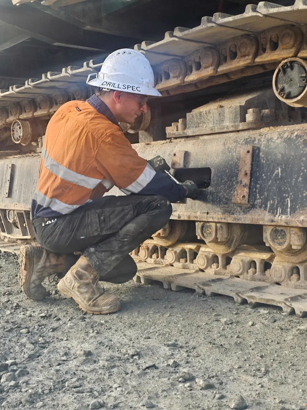 Drillspec technician inspecting an excavator track frame