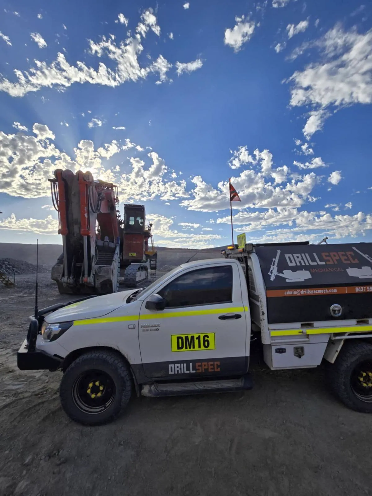 Drillspec DM16 service ute alongside a tracked hydraulic excavator on a WA mine site