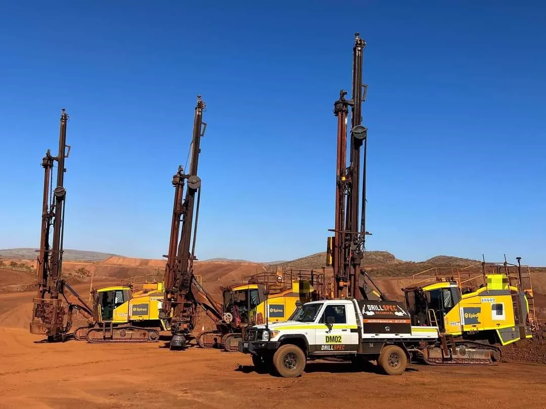 Drillspec service vehicle alongside drill rigs at open pit mine