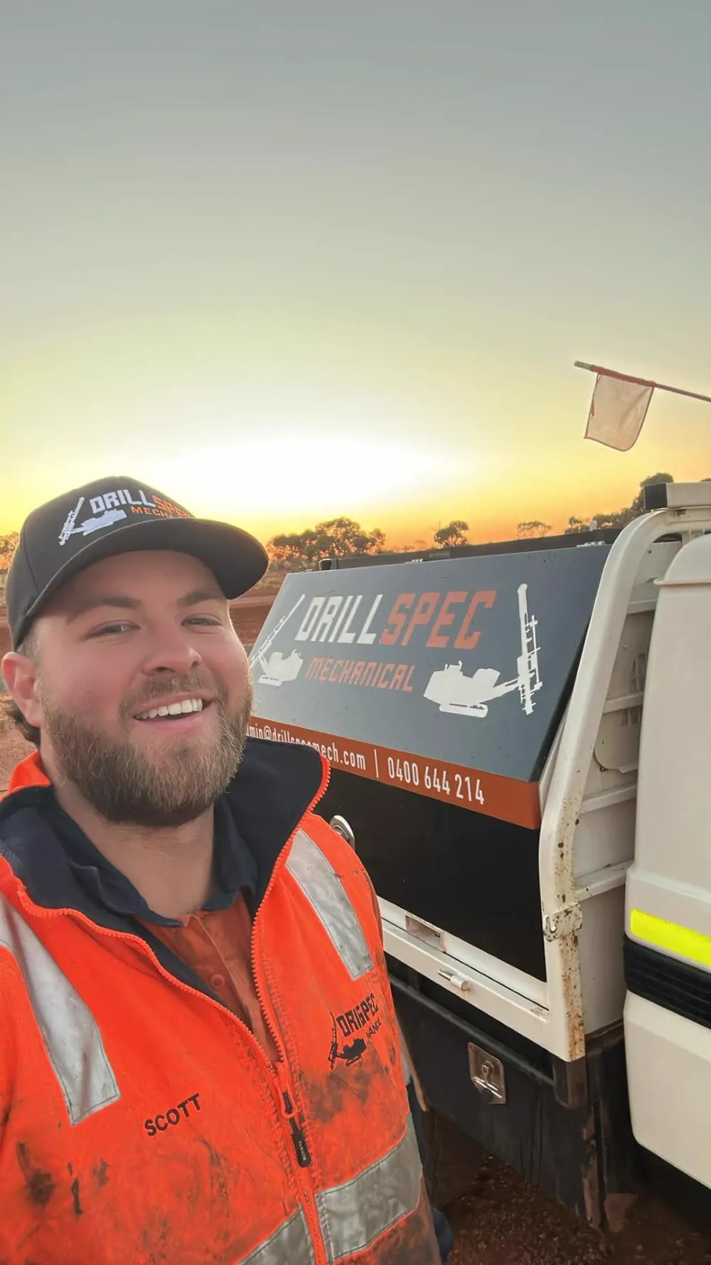 Drillspec field-service tech beside the DM service ute at sunset