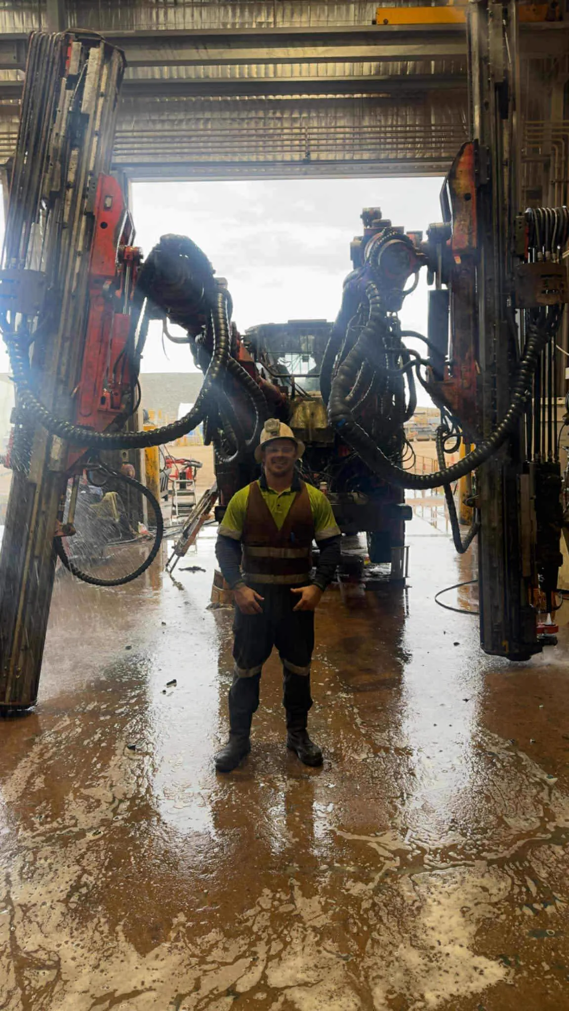 Drillspec mechanic standing in front of drill rig in workshop