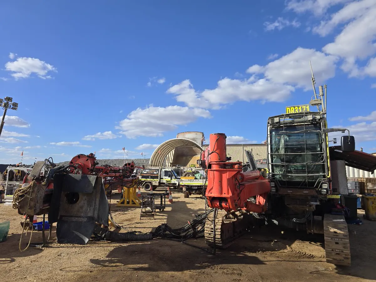 Sandvik Leopard surface drill DR3171 mid-strip in the shut laydown, boom and mast components staged on stands