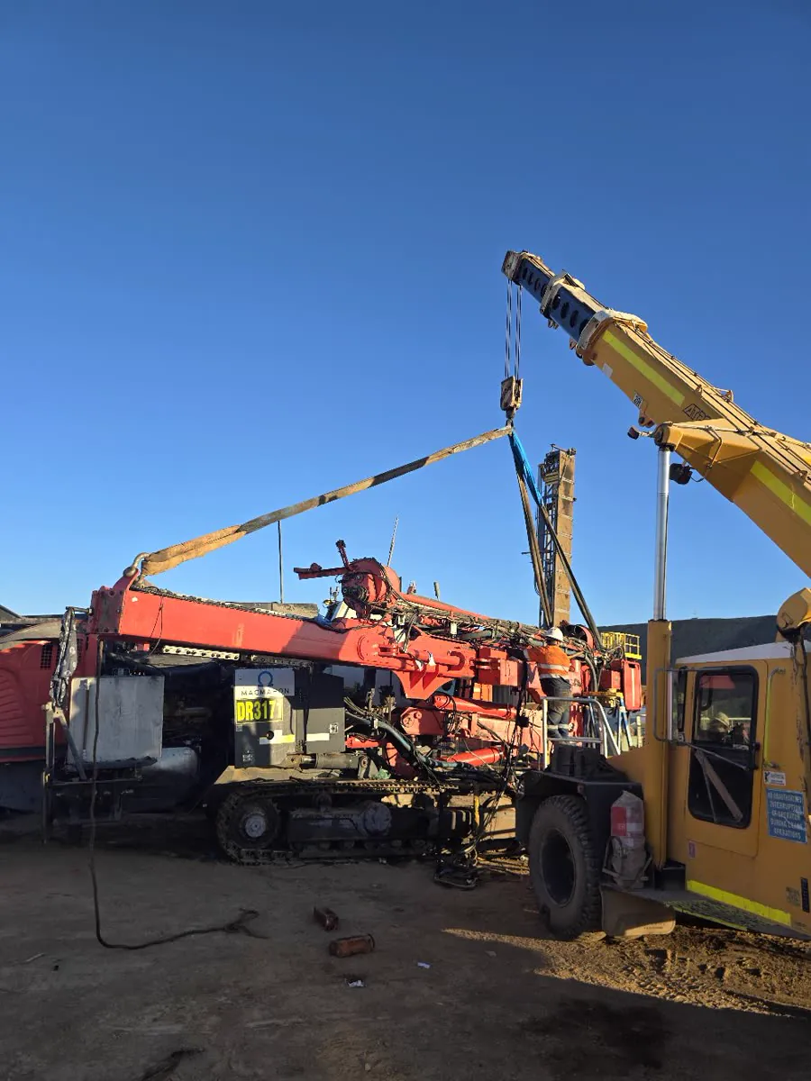 Crane lifting the boom on Leopard DR3171 with a Drillspec tech guiding the lift