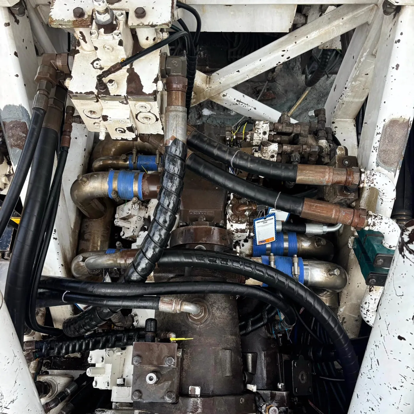 The rig's hydraulic manifold and lines reconnected around the new pump, fresh fittings capped
