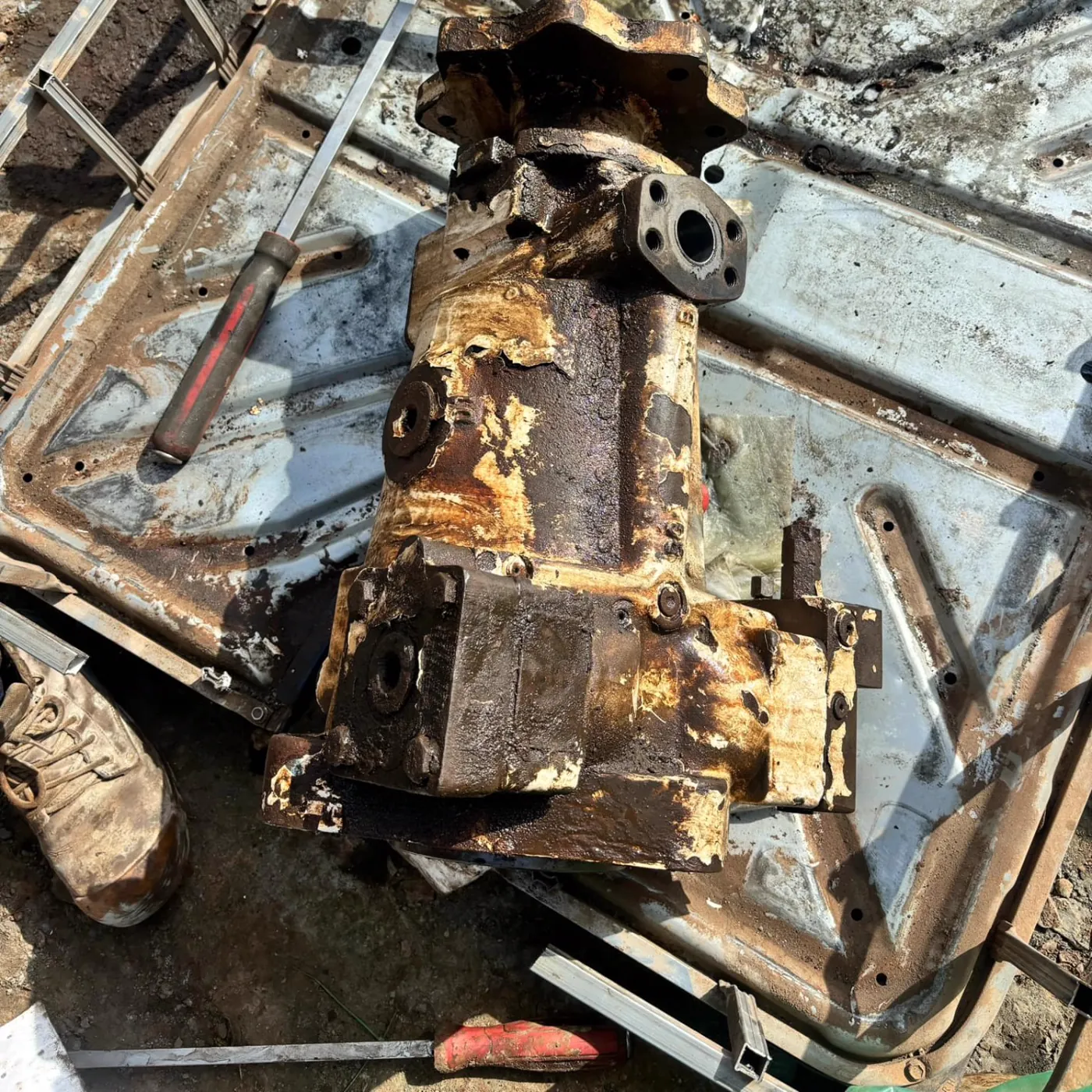 The failed rotation pump removed from the rig, rusted and worn, on the ground